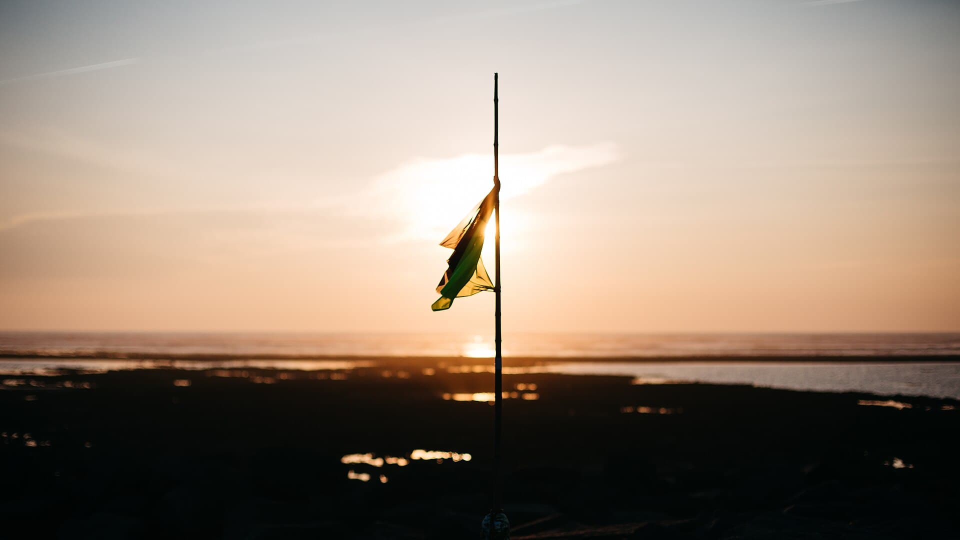 Coucher de soleil orangé sur l'estran découvert d'Ars-en-Ré, sur l'ile de Ré, la mer et le ciel se confondant a l'horizon.