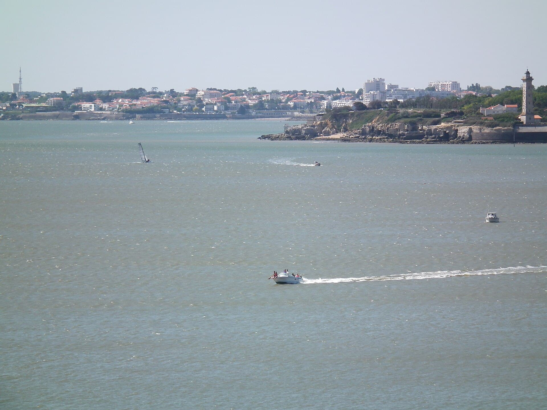 Vue sur la baie depuis Saint-Georges-de-Didonne, avec la pointe rocheuse, le phare et les maisons du front de mer de Royan à l'horizon